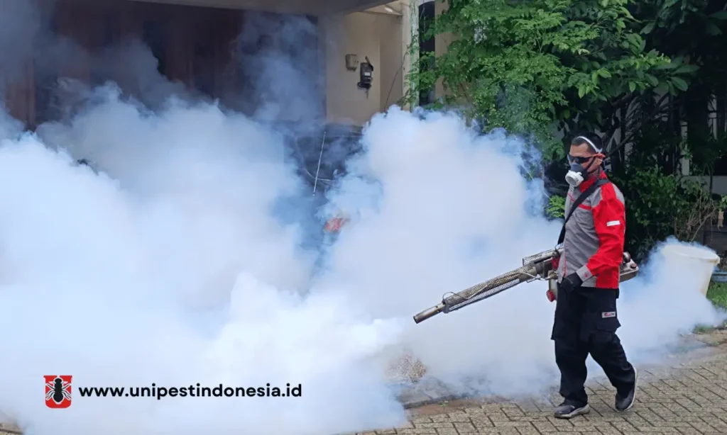 Petugas melakukan fogging nyamuk di area perumahan dengan mesin pengasap